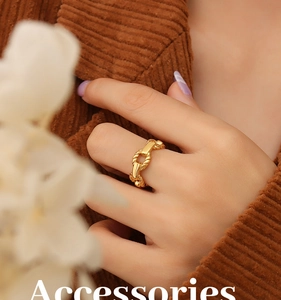Macro view of a 18K gold plated hollow chain ring on a finger with warm aesthetic tones