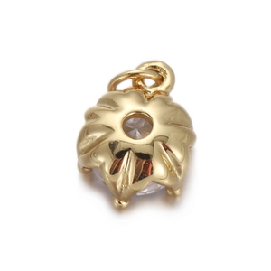 Detail of flower-shaped gold plated charm with a sparkling central zircon stone