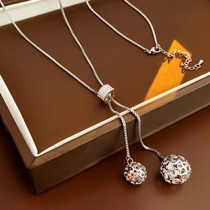 Détail du collier réglable en argent avec globes évidés et incrustations de zircons