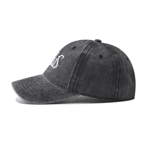 Dettaglio del ricamo bianco PARIS sul lato del cappellino vintage in cotone nero