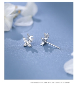 Macro shot of sparkling zircon butterfly studs in S999 sterling silver with mirror finish