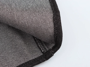 Makroaufnahme von schwarz-weißem Jeansstoff mit feinen schwarzen Nähten im Detail