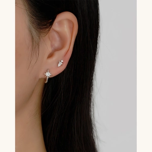Detailed close-up of S925 silver star earrings with zircon inlay on model's ear