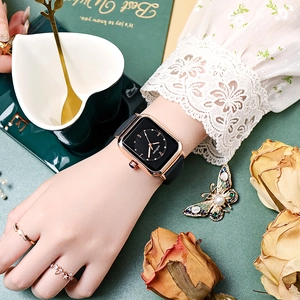 Detail of square rose gold watch with black dial worn on wrist with vintage props