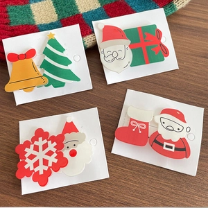 Cute Christmas hair clips set featuring Santa, tree, and bells on a white display card