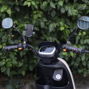 Detail of vintage black leather handlebar covers with lace-up design and phone mount