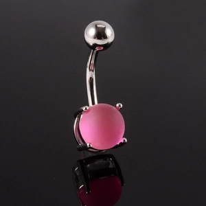 Détail macro d'un piercing nombril argenté avec boule en résine rose mat sur fond noir