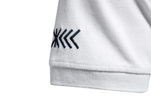 Macro detail of breathable pique fabric on a white polo shirt sleeve with embroidered logo