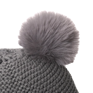 Close-up of grey knitted hat featuring soft faux fur pom-poms and ribbed knit texture