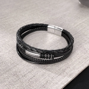 Detail of multi-layer black braided leather bracelet with silver magnetic clasp