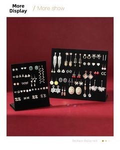 Close-up of black velvet L-shaped earring display stands with various stud earrings