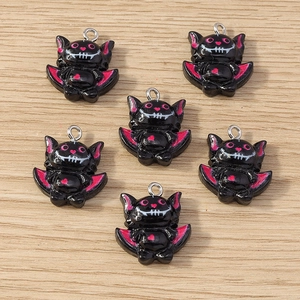 Detailed view of black resin bat charms with pink accents and metal rings for DIY jewelry