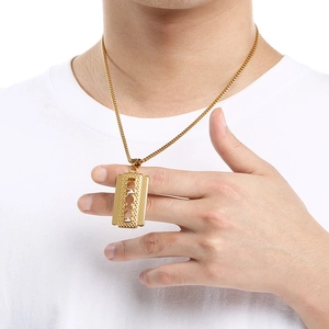 Macro detail of men's gold stainless steel razor blade pendant with geometric hollows