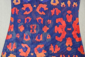 Détail du tissu en maille léopard avec dégradé bleu et orange et couture à bord roulé