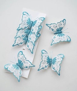Detail eines weißen Stoff-Schmetterlings mit blauem Glitzer und Pailletten für Dekoration