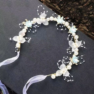 Detail von Blumenhaarreif mit weißen Perlen, blauen Blumen und weißen Chiffonbändern