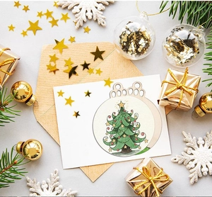Flat-lay detail of a wooden Christmas tree ornament on a card with festive props