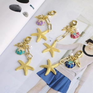 Golden ocean series keychain featuring colorful enamel starfish and seashell pendants