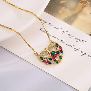 Close-up of golden butterfly pendant necklace with colorful zircons on a romantic card