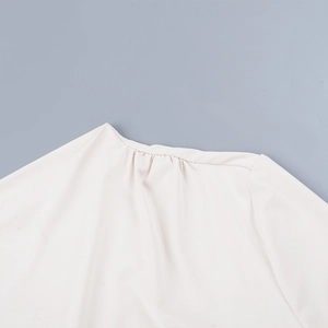 Détail de l'encolure plissée élégante et de la texture fine du tissu sur le haut à manches