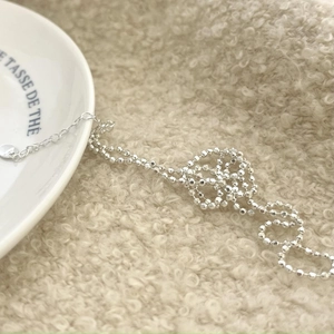 Detailed macro view of 925 sterling silver beaded necklace with round pendant and toggle chain