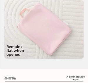 Detail of a pink waterproof travel organizer bag showing side handle and zipper closure