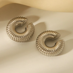 Close-up of silver-tone spiral textured C-shape clip-on earrings with metallic finish
