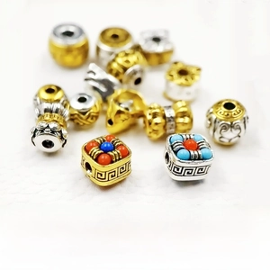Macro view of two-color silver plated Tibetan barrel beads with intricate relief details