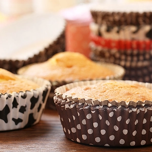 Detail of oil-proof cupcake liners featuring brown dots and cow print patterns for baking