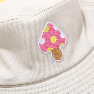 Beige canvas bucket hat featuring colorful mushroom embroidery and cotton twill texture