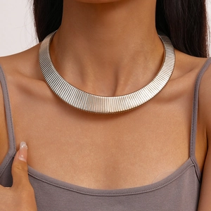 Detail of silver textured metal choker necklace with vertical stripe texture on neck