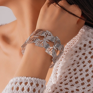 Close-up of a silver-tone hollow butterfly open cuff bracelet worn on a wrist