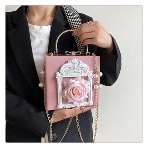 Detail of pink baroque handbag featuring a 3D resin flower and vintage relief frame