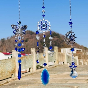 Blue evil eye crystal suncatchers with butterfly and moon hanging in the garden