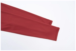 Détail des coutures à double aiguille sur les manches de la tenue de yoga rouge foncé