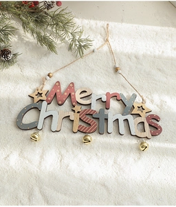 Detailed view of a Merry Christmas wooden hanging sign with festive bells and pine cones