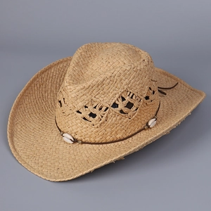 Close-up of woven straw cowboy hat with hollow diamond vents and shell decoration