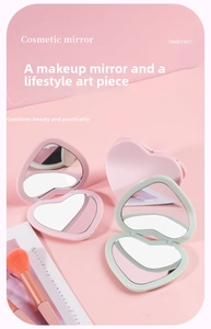 Close-up of heart-shaped folding cosmetic mirrors in pink and green on a soft background