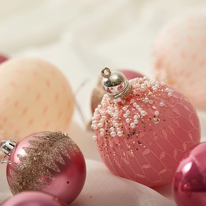 Rosa und goldene Weihnachtskugeln mit zartem Spitzennetz, Perlen und Glitzerblättern