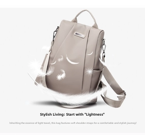 Detail view of lightweight beige Oxford cloth backpack with silver metal plate and feathers