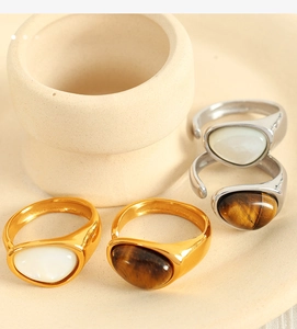 Close-up of vintage 18k gold and silver rings with natural tiger eye and mother of pearl