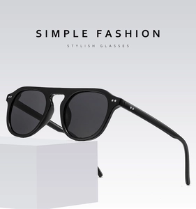 Close-up of minimalist black pilot sunglasses with metal rivets on geometric white block