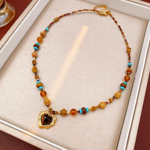 Detail of vintage heart pendant with multi-colored gemstone beads in a gift box