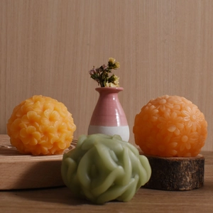 Floral silicone candle molds featuring 3D rose and daisy designs on rustic wood