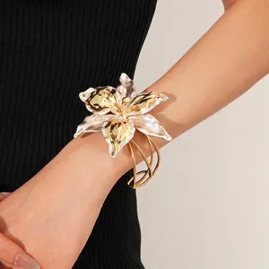 Exaggerated gold lily flower open cuff bracelet with white petals and woven metal lines