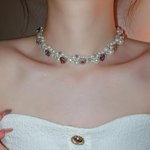 Detail of beaded pearl choker with pink crystal hearts on female model neck
