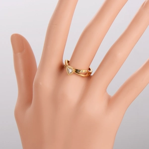 Elegant gold heart ring with cubic zirconia stones and cutout band on hand model
