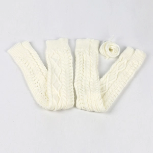 Detailed view of white knitted leg warmers featuring classic cable knit texture and ties