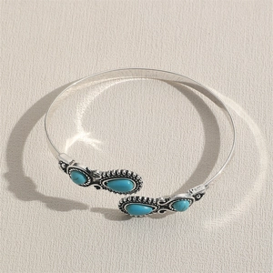 Detail of silver alloy cuff bracelet with turquoise stones and bohemian patterns