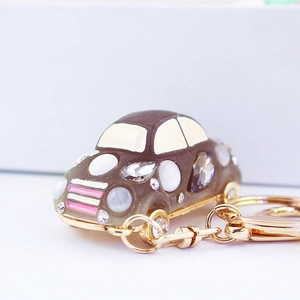 Car keychain with grey rhinestones, white gemstones and gold metal chain for handbags